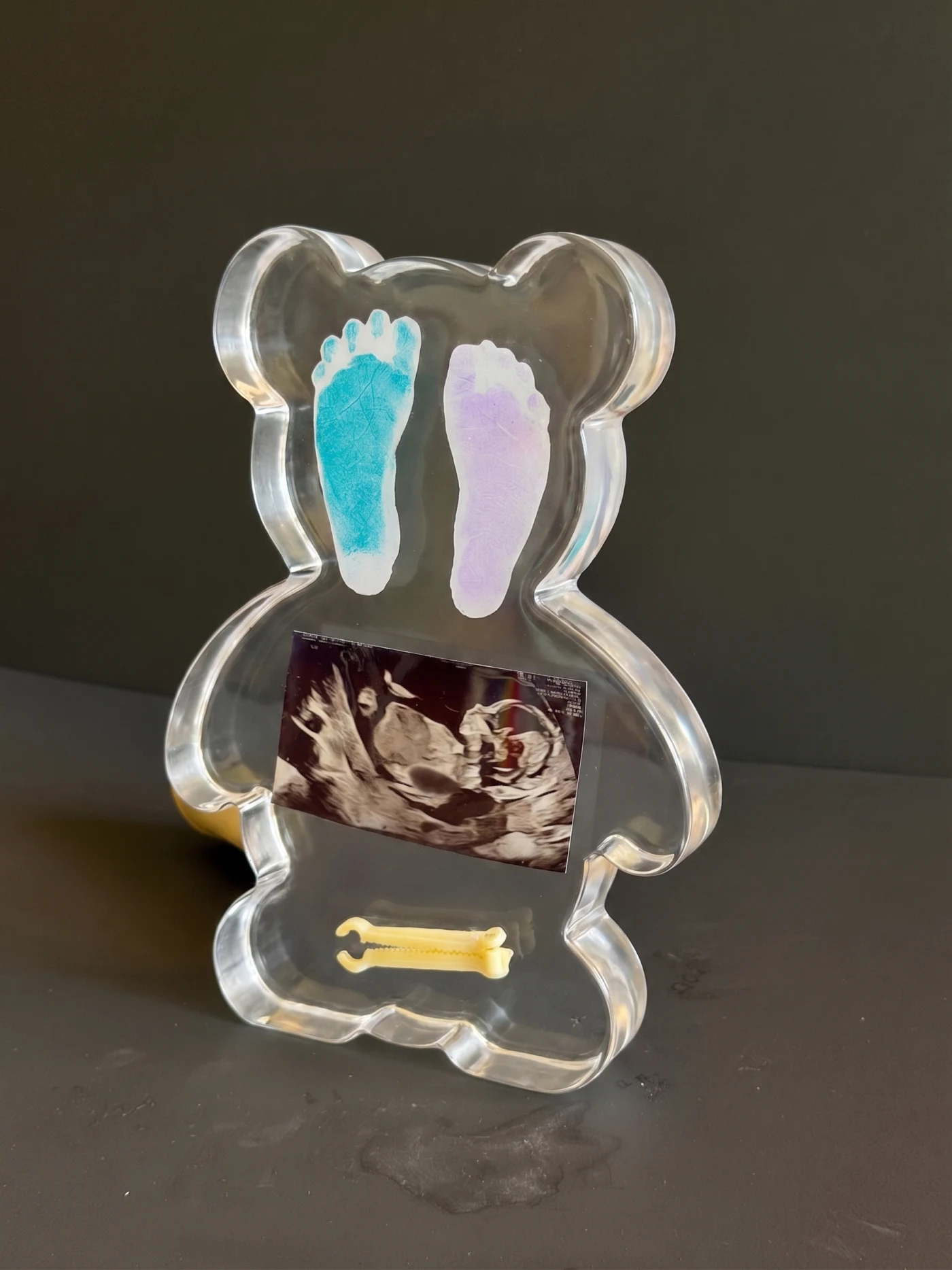 Angled view of a clear resin teddy bear baby keepsake