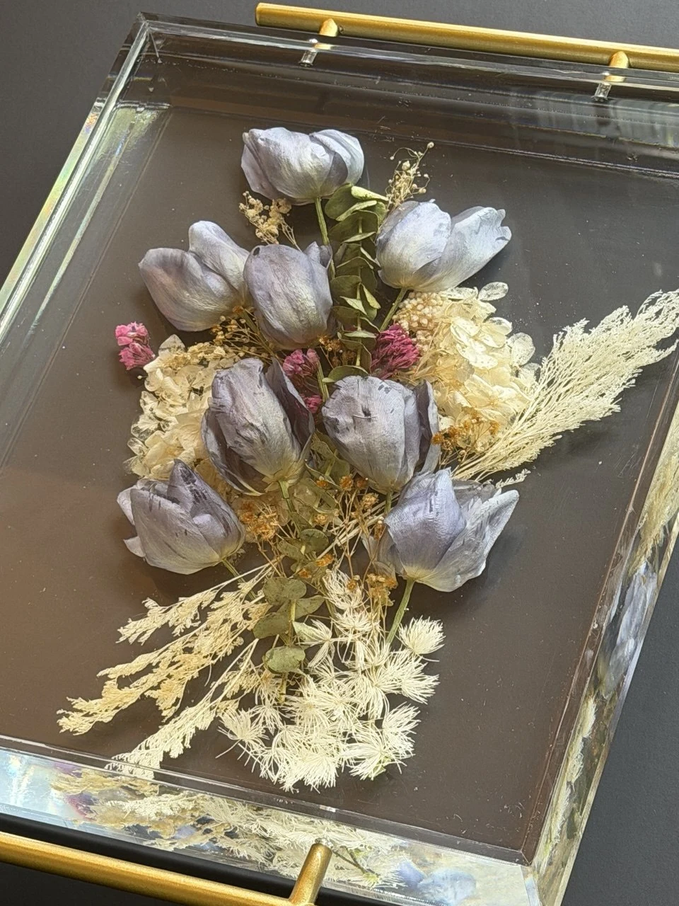 Close detail of a clear resin wedding-flower tray with gold handles